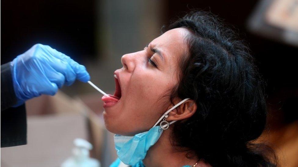 A woman undergoes a nasal swab test to detect COVID-19 at the railway station in Bangalore, India, 31 December 2021.