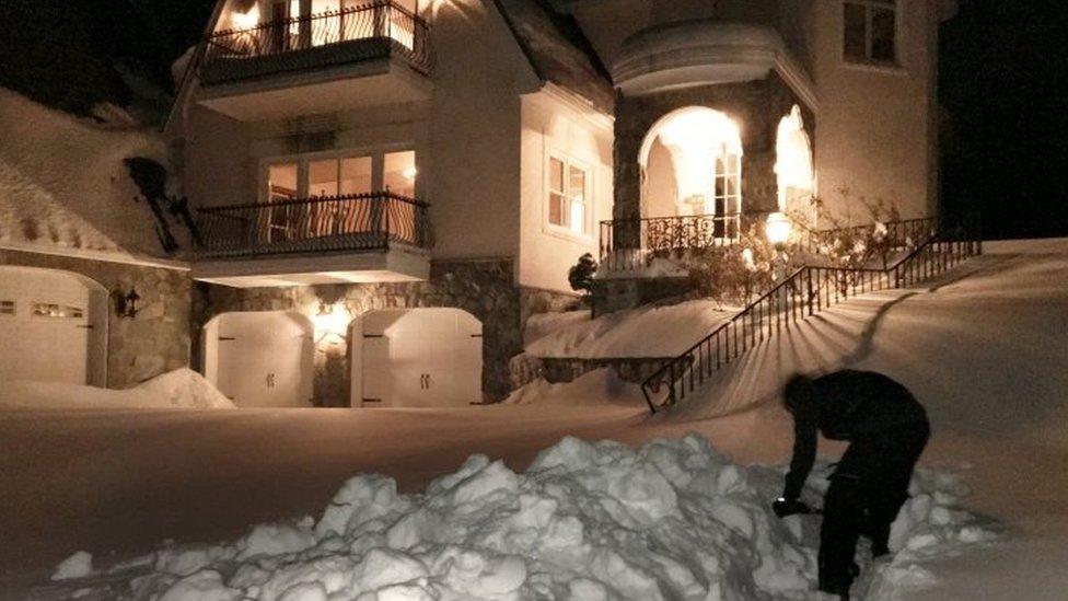 A man digs out snow outside his home in Great Falls, Virginia (25 January 2016)