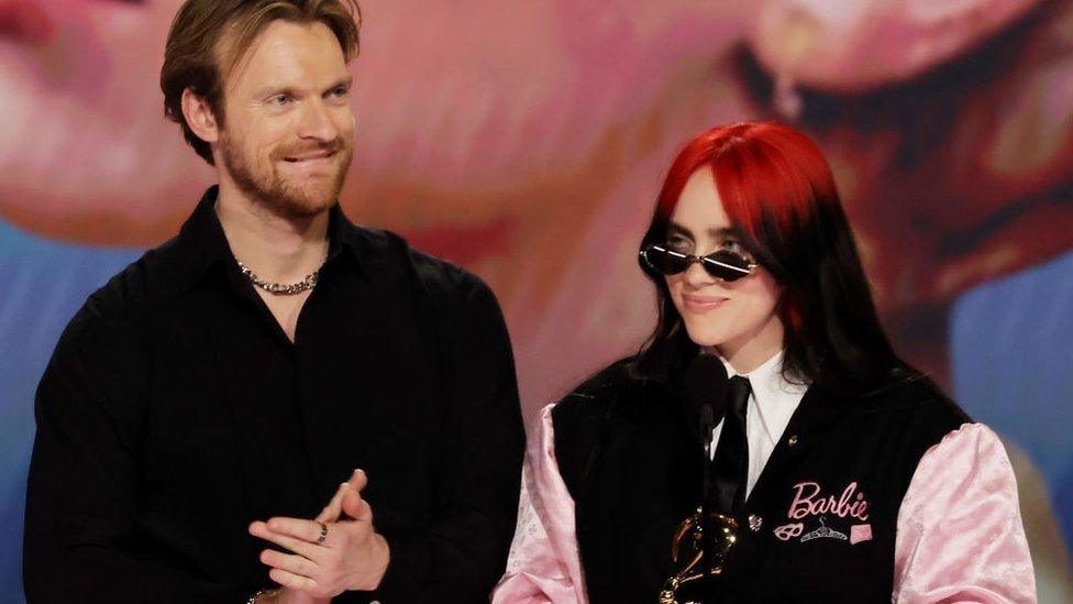 finneas and billie eilish with a grammy award on stage