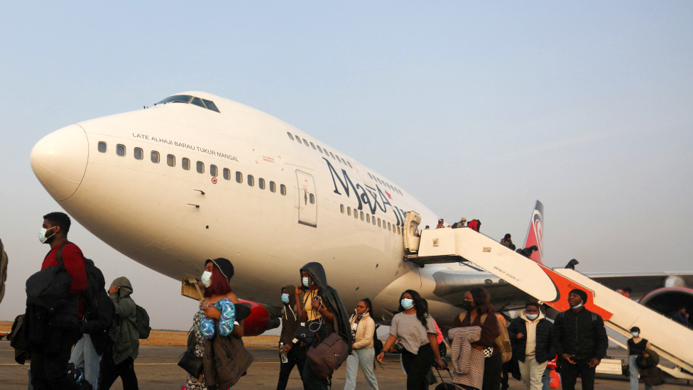 Passengers disembarking from an aeroplane in Abuja, Nigeria