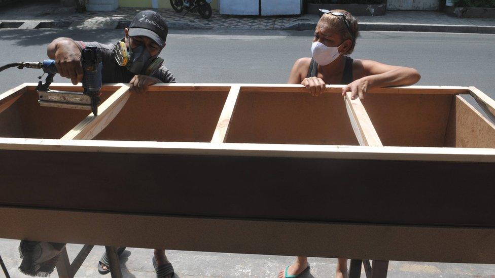 Furniture-maker and his wife working on a coffin in Guayaquil, 16 Apr 20