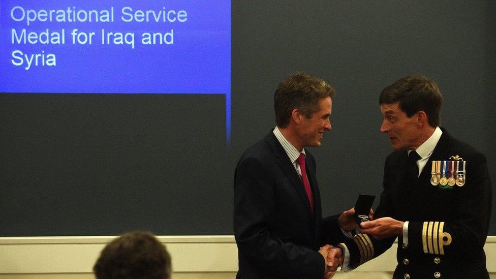 Defence Secretary Gavin Williamson presents a new Operation Shader medal to a serviceman