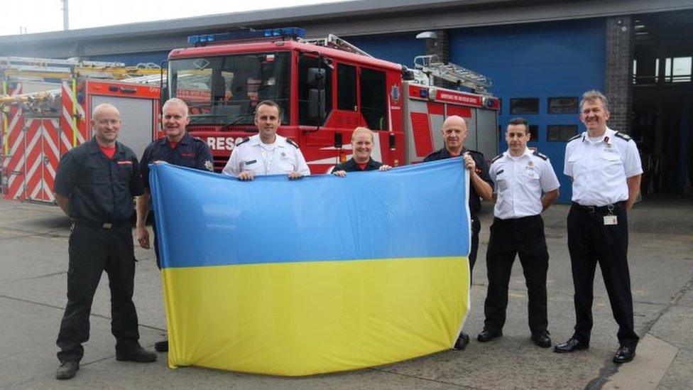 Firefighters holding a Ukrainian flag