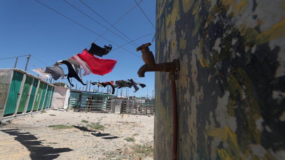 Clothing hangs above a communal tap in Khayelitsha township, near Cape Town, South Africa, 12 December 2017