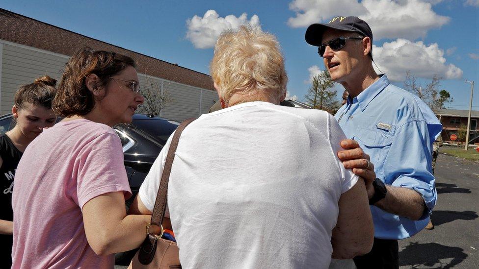 Florida Gov. Rick Scott (R), comforts a family displaced after their home was damaged by Hurricane Michael