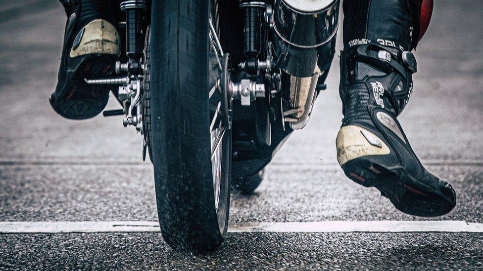 Back wheel of motorcycle and riders boots