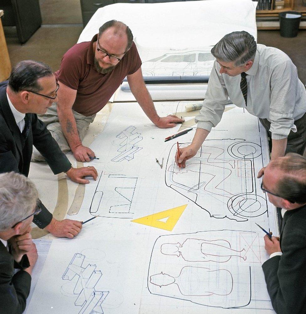 Designers look over plans for the new car