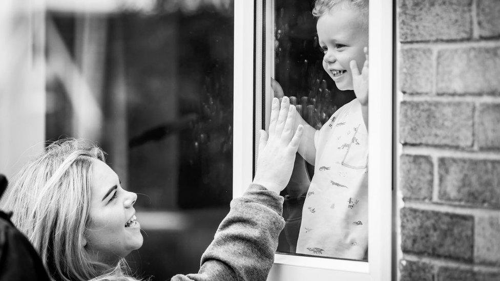 Charlotte Cole touches window to greet son