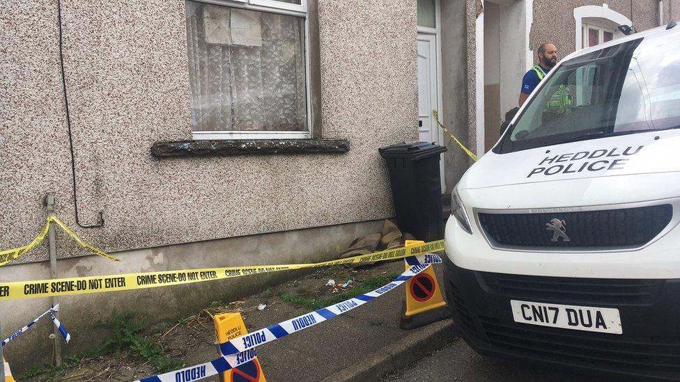 A police officer and van at the house in Lewis Street, Bedlinog