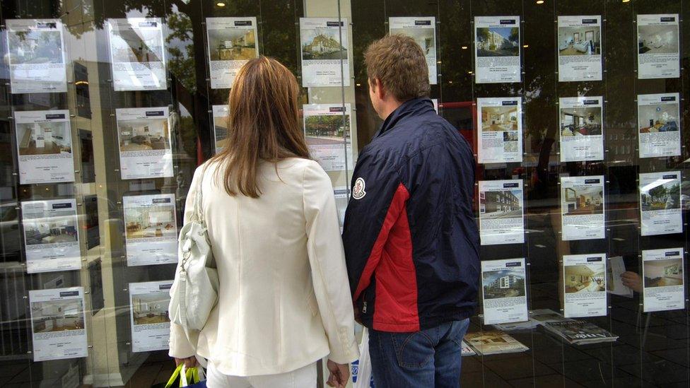 Couple outside an estate agent's window