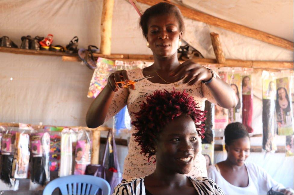 Refugee entrepreneur Penina cutting hair