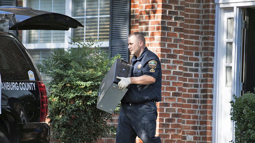 A police officer carries a computer out of the home of Todd Kohlhepp in Moore, South Carolina - 3 November 2016