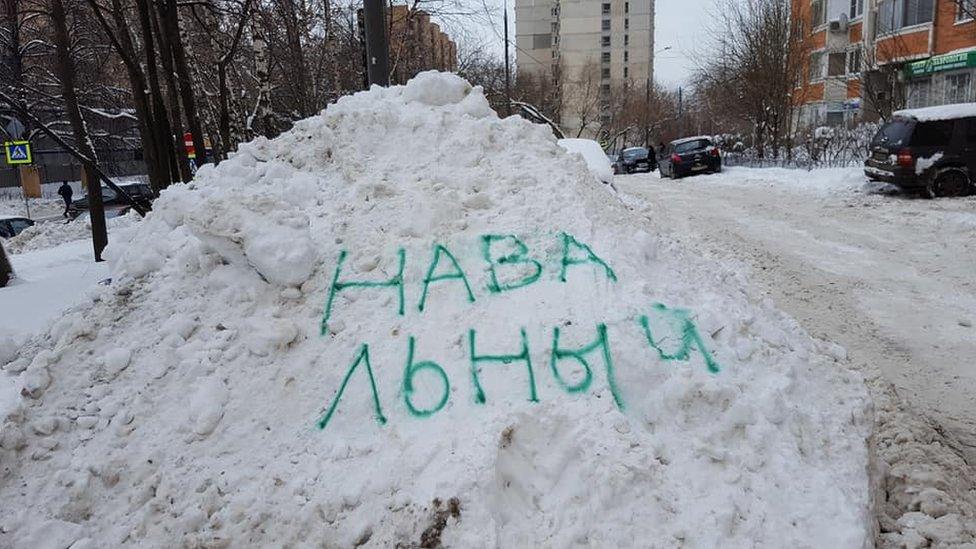 The name of Russian opposition leader Alexei Navalny spray-painted on a snow drift in Moscow.