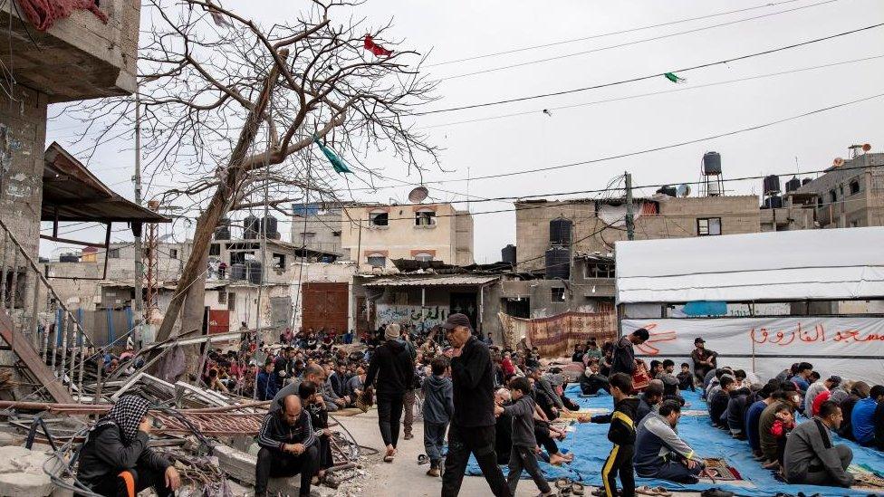 Displaced Palestinians perform the third Friday prayer of the holy month of Ramadan next to the ruins of a mosque destroyed earlier by an Israeli raid in Rafah, southern Gaza Strip, 29 March 2024.