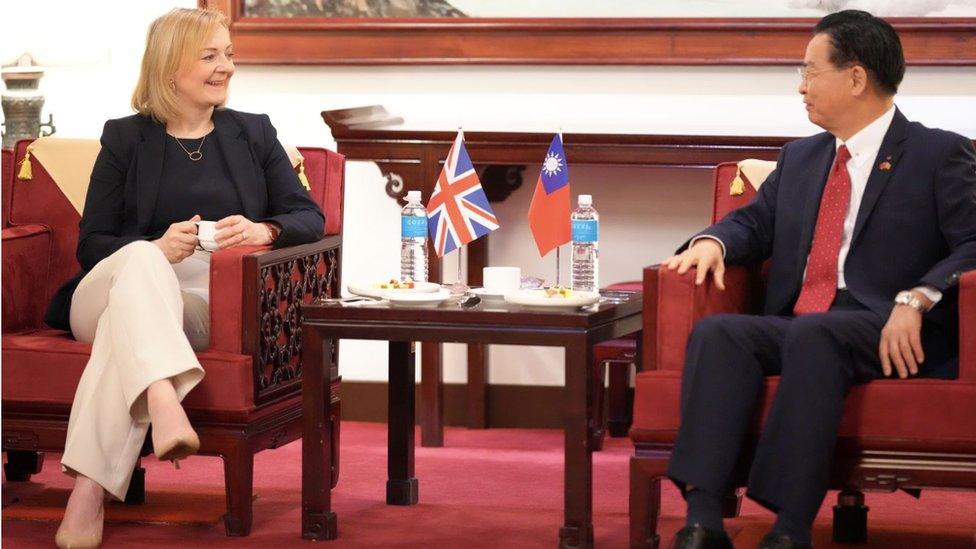 Britain's former Prime Minister Liz Truss (L) speaking to Taiwan's Foreign Minister Joseph Wu upon her arrival at the Airport in Taoyuan