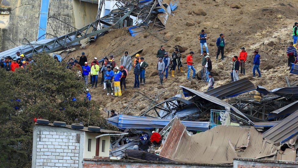 Rescuers search for victims after a landslide in Alausi, Ecuador, 27 March 2023.