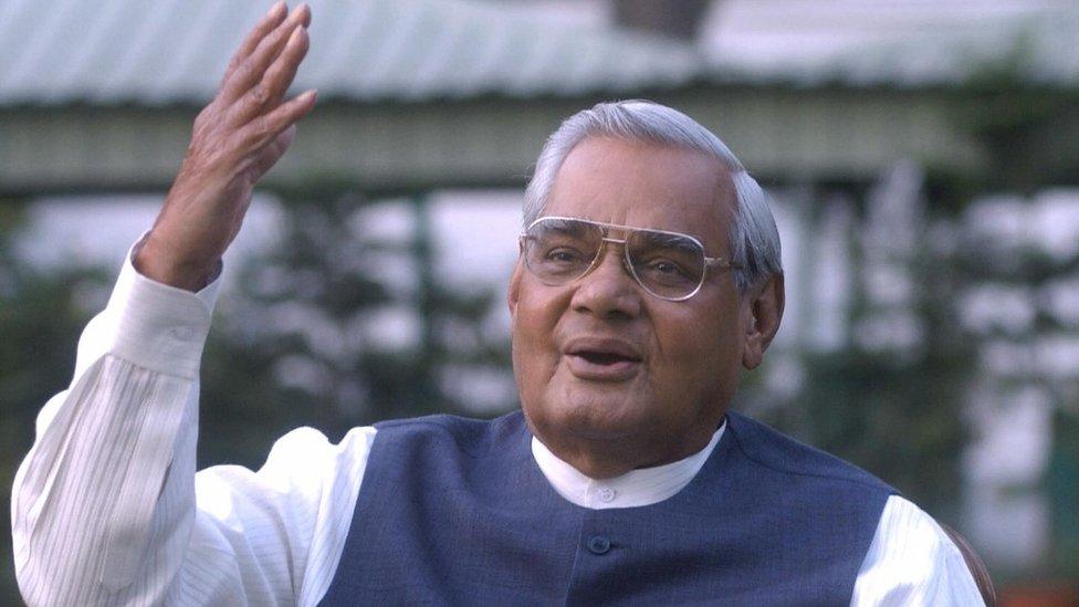 India's Prime Minister Atal Behari Vajpayee gestures as he poses for photographers at his residence in New Delhi, 25 March 2004.