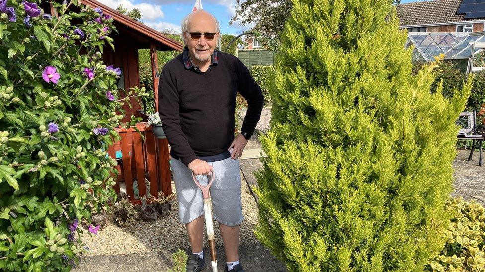 Steve Perry holding spade in his garden