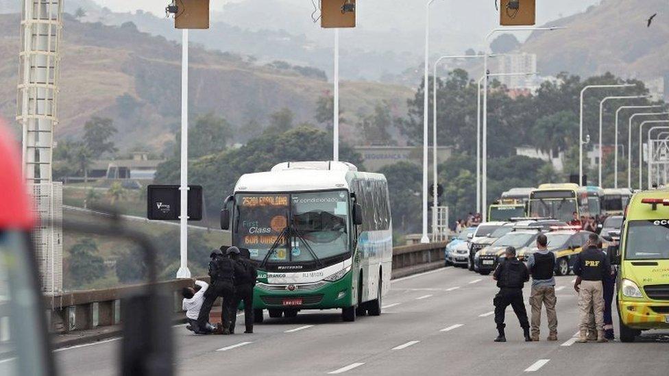 A woman faints as she gets off the bus where a man is holding passengers hostage in Rio