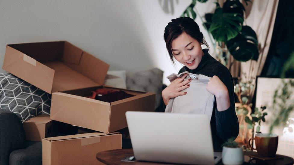 Stock image of someone unpacking a bit of online clothes shopping