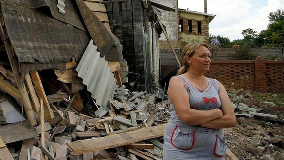 A woman stands near of her damaged home in the pro-Russian rebel-controlled city of Horlivka