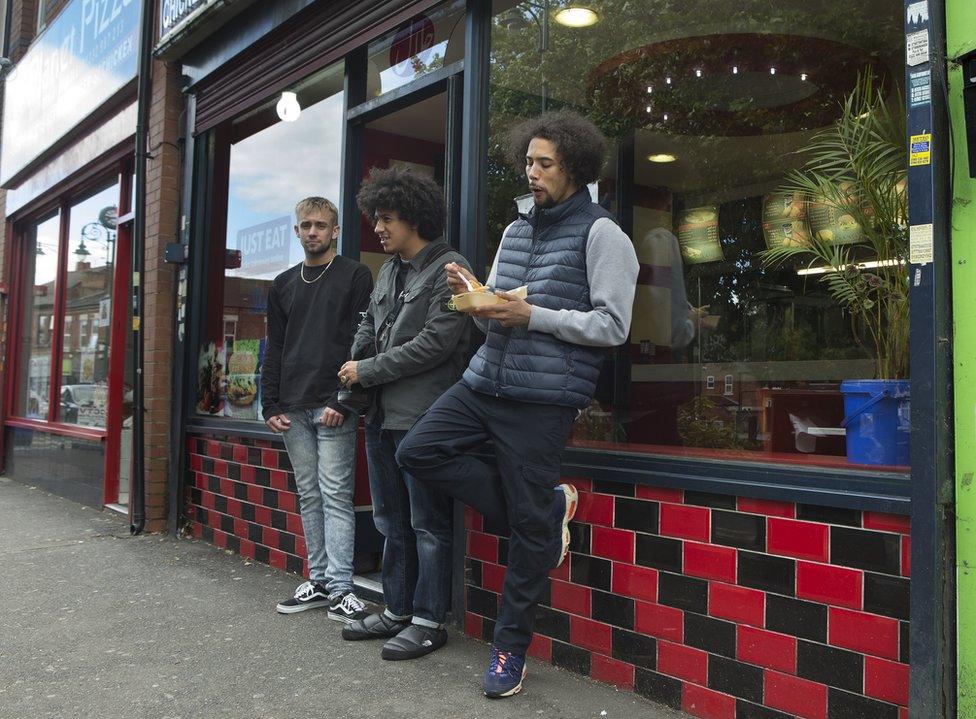 Local Geezers stand outside a takeaway