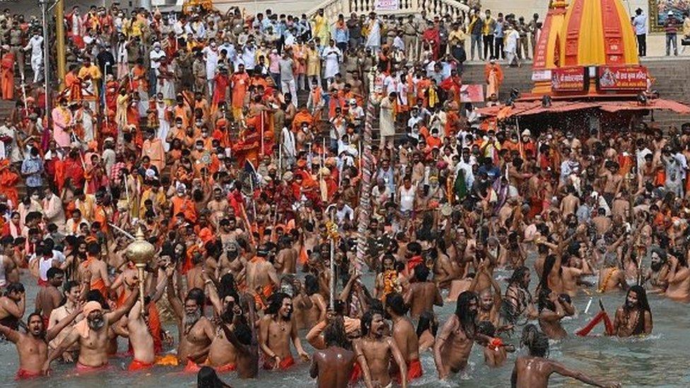 Naga Sadhus (Hindu holy men) take a holy dip in the waters of the Ganges River on the day of Shahi Snan (royal bath) during the ongoing religious Kumbh Mela festival, in Haridwar on April 12, 2021.