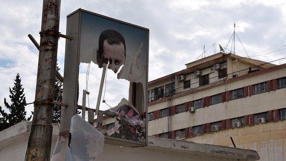 A ripped picture of Syrian President Bashar al-Assad hangs in the northern Syrian city of Raqqa on 5 March 2013