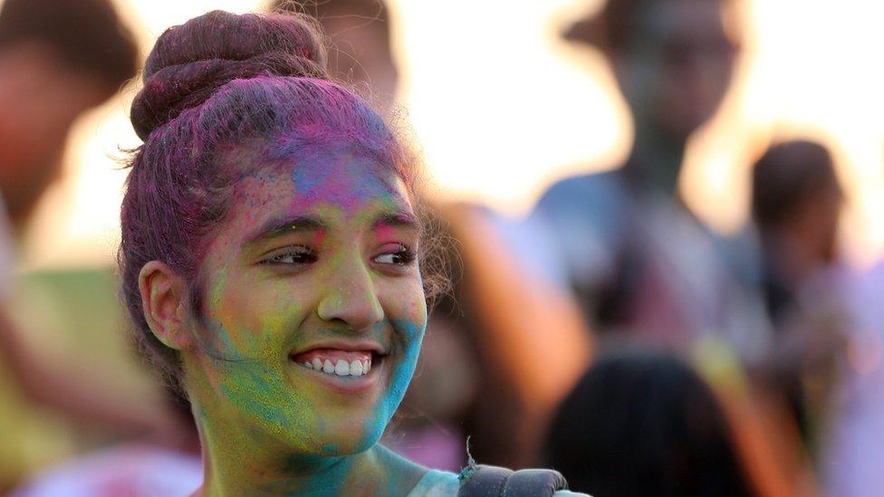 A Festival-goer is covered with colored powder during the music and color festival at the Golf Citrus in Hammamet south of Tunis, 27 Tunisia August 2016