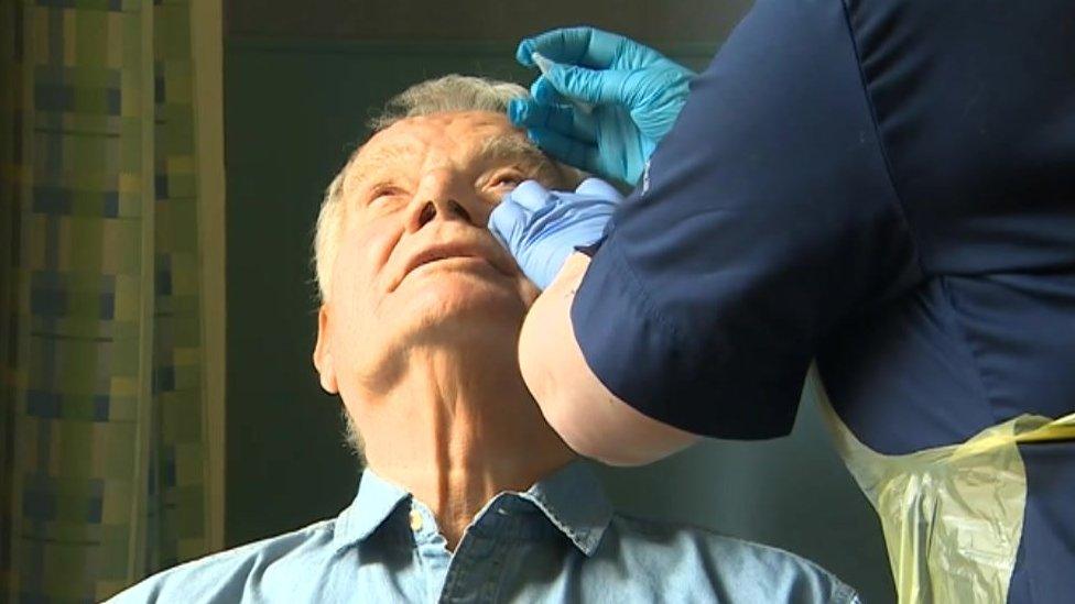 Man receiving eye drops