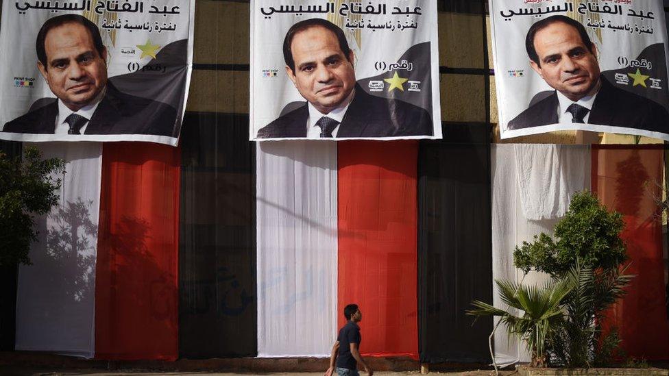 Man walks past election posters of Egyptian President Abdul Fattah al-Sisi (March, 2018)