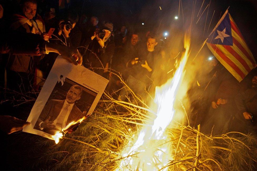 People burn images of Spain's King Felipe VI as they attend a protest against the detention of former Catalan leader Carles Puigdemont in Girona, Catalonia, north-eastern Spain, 25 March 2018.