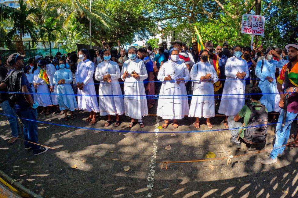 Sri Lankan catholic nuns shield the protesters during a protest near the president's office at Colombo, Sri Lanka. 24 April 2022.