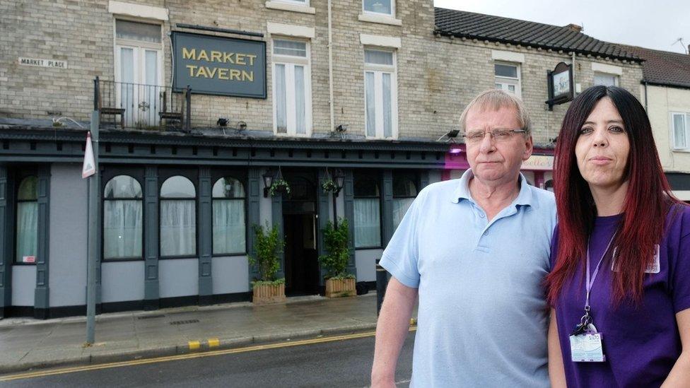 Man and woman stand outside pub