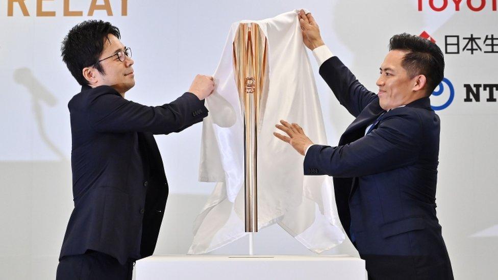 designer Tokujin Yoshioka (L) and Torch Relay Ambassador Tadahiro Nomura unveil the Tokyo 2020 Olympic Games torch