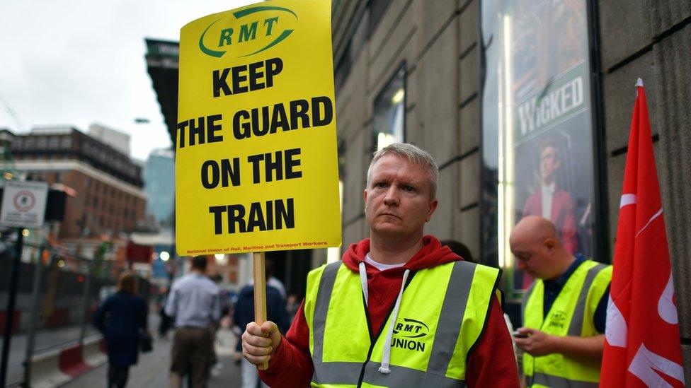 An RMT union member holds up a placard