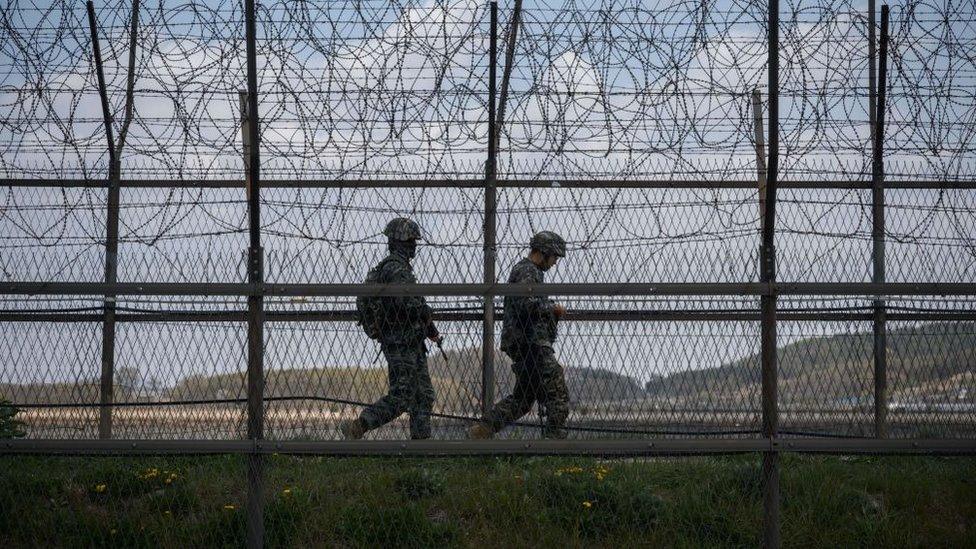 South Korean soldiers patrol along a barbed wire fence Demilitarized Zone (DMZ) separating North and South Korea, on the South Korean island of Ganghwa on April 23, 2020.