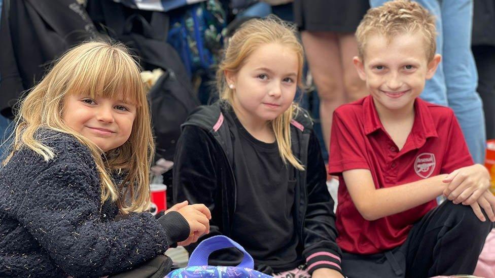 Three children outside Buckingham Palace during the Queen's State Funeral