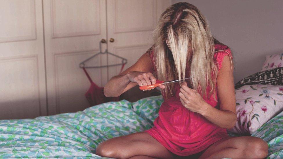 A woman cutting her own hair