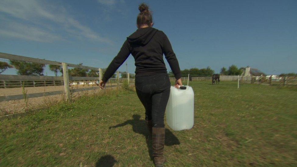 Heather McMillan carrying water