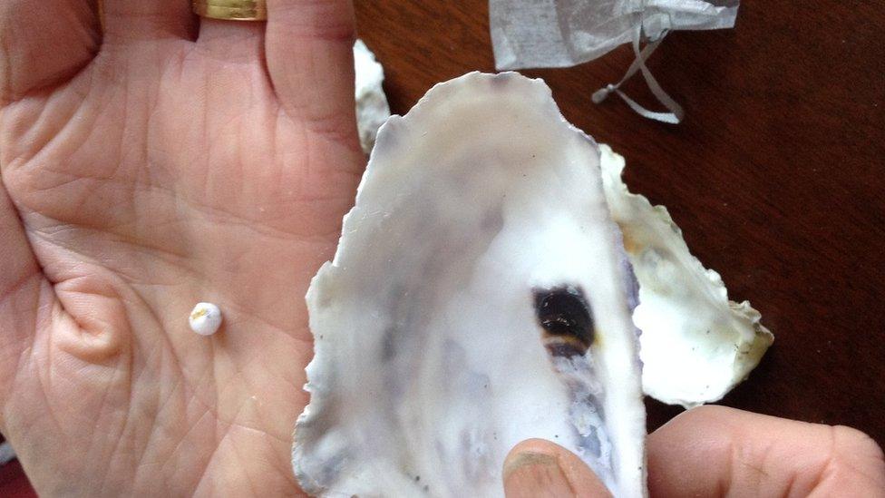 Oyster and pearl in hand