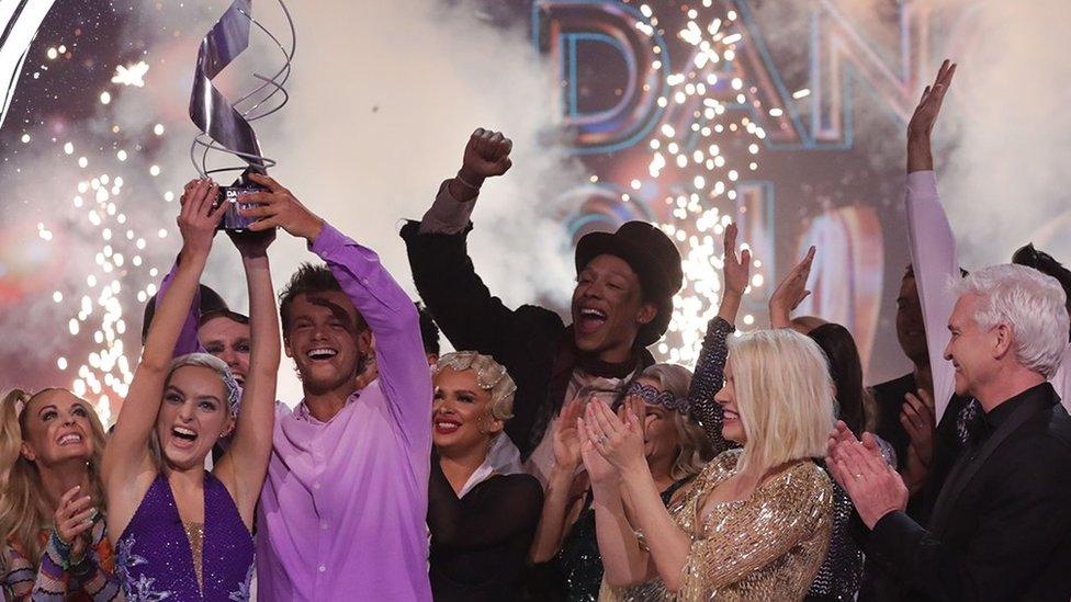 Regan Gascoigne and his pro partner Karina Manta lift the Dancing on Ice trophy.