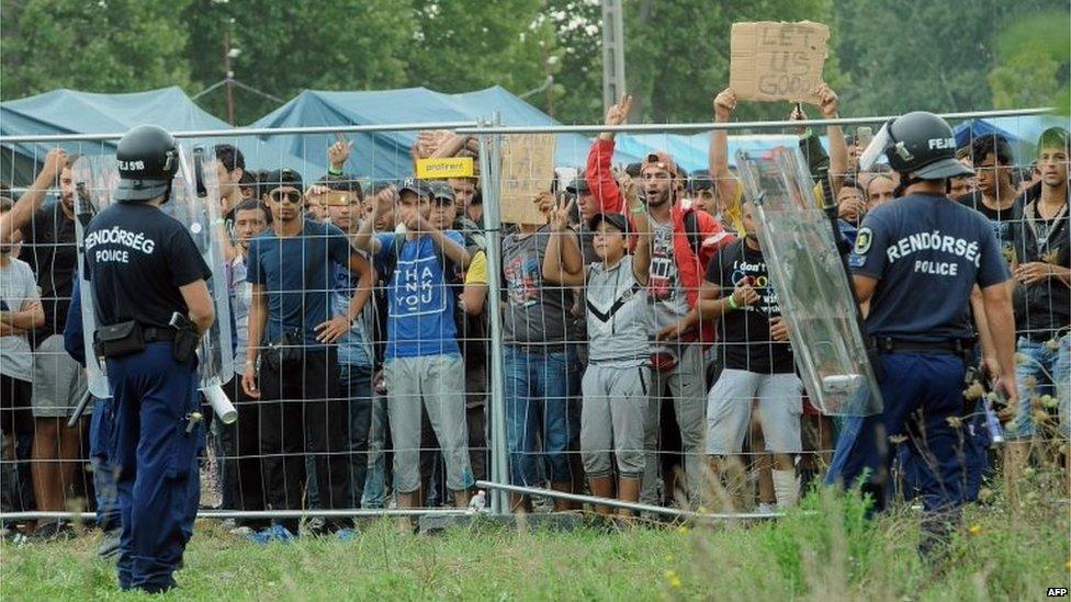 Police officers guard a local refugee camp in the village of Roszke at the Serbian-Hungarian border on September 4, 201