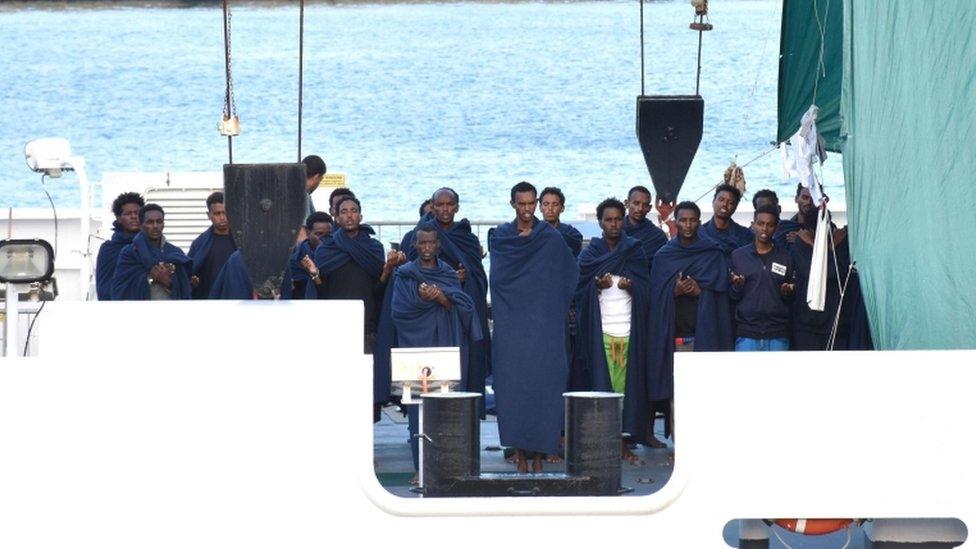 Migrants on ship wrapped in blankets