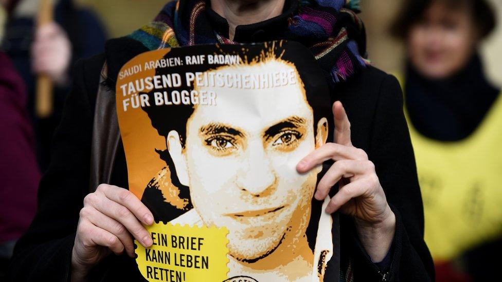 Amnesty International activist holds picture of Saudi blogger Raif Badawi during protest in Berlin on January 29, 2015