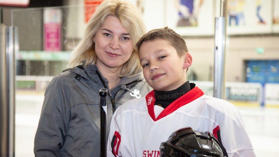 Kateryna and Kateryna smile while standing in front of an ice rink