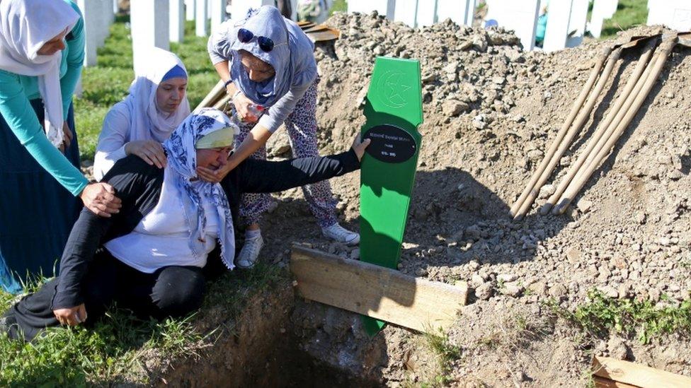 Women cry near the grave of their relative, who is amongst the 136 newly identified victims of the 1995 Srebrenica massacre that have been lined up for a joint burial, in Potocari