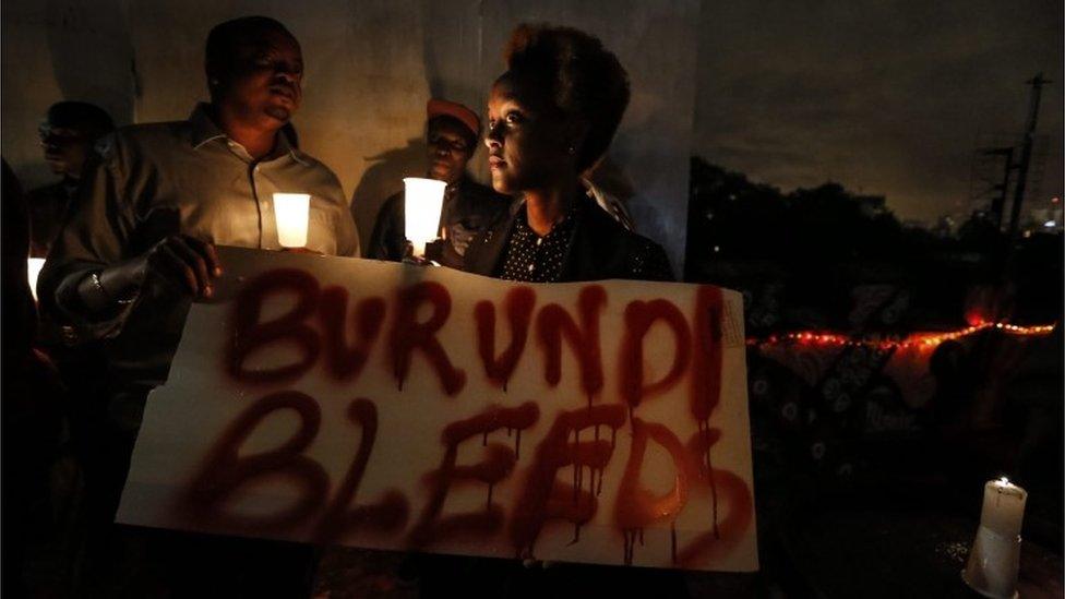 A Burundian expatriate woman holds a placard reading "Burundi bleeds" during a candlelight vigil held for Burundi in Nairobi, Kenya, 13 December 2015