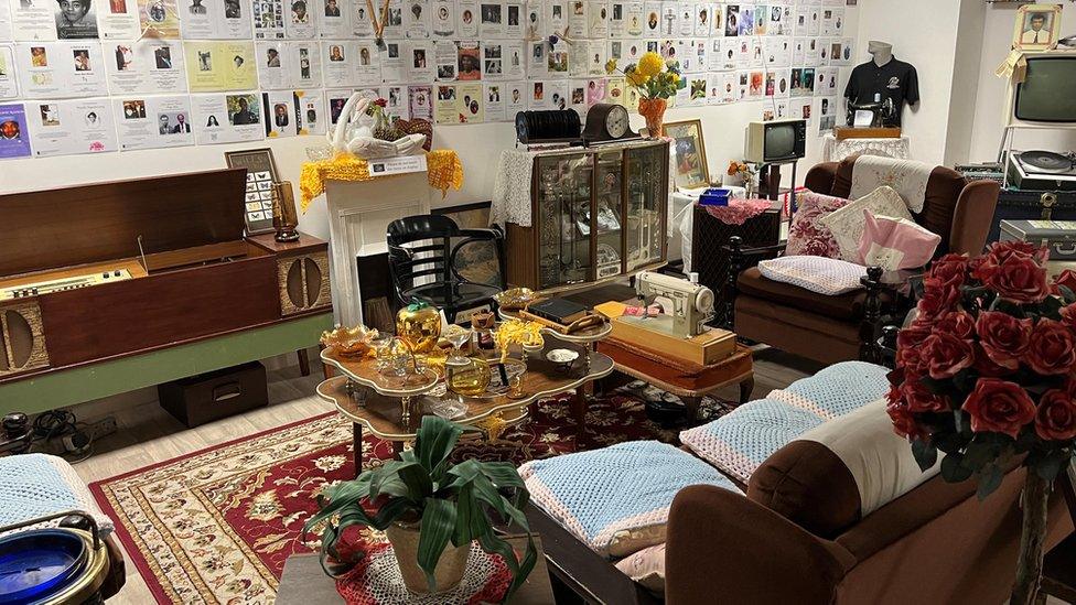 A living room layout with 1940s furniture, with sofas and a coffee table in the centre.