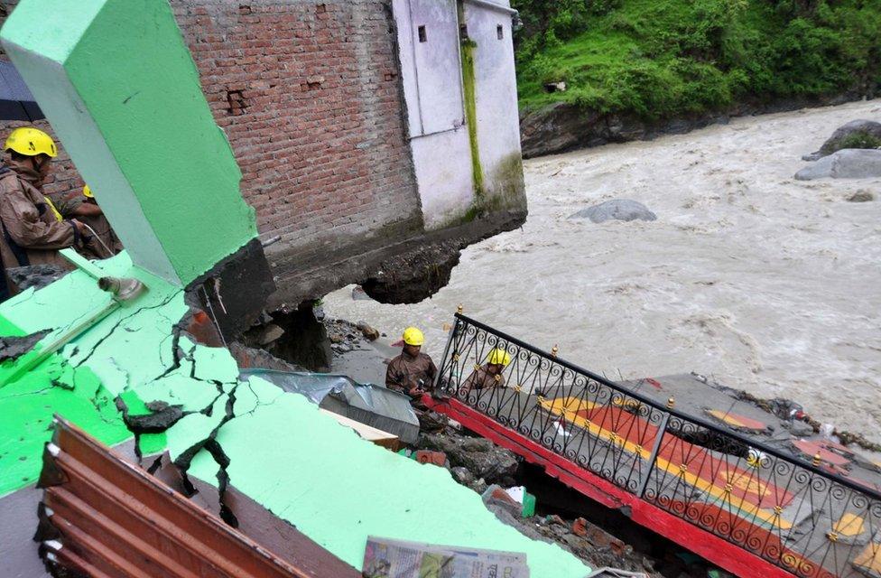 In this photograph taken on July 3, 2016, Indian State Disaster Response Force (SDRF)personnel examine the wreckage of a building after monsoon floodwaters devastated dwellings in the village of Ghat, near Karanprayag, Chamoli District in the northern state of Uttarakhand.